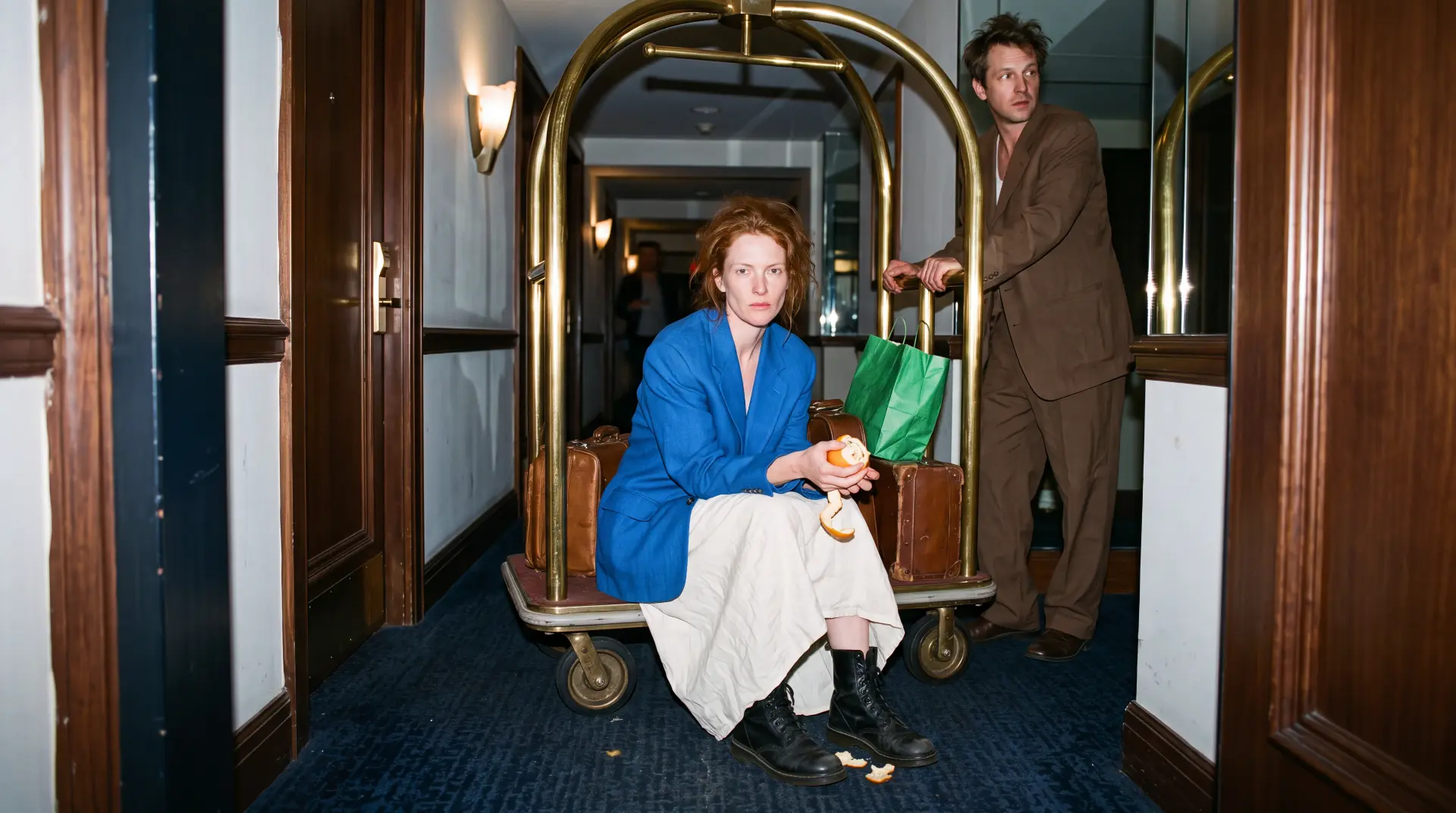 Aufnahme aus dem Portfolio von Chris Jean: Frau sitzt auf einem Gepäckwagen in einem Hotelkorridor